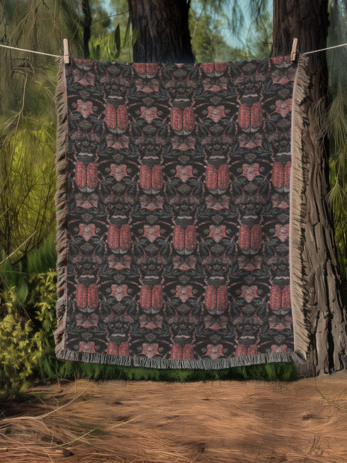 Luxurious woven cotton throw blanket featuring symmetrical scarab beetle pattern in terracotta on black background with white fringe detail. Perfect as gothic wall tapestry, dark academia decor, or cottagecore blanket for bedroom or living room.